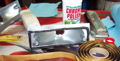 1985 Ford Crown Victoria LTD - A car part, likely a taillight housing, is prepared for installation with gasket material and chrome polish nearby.