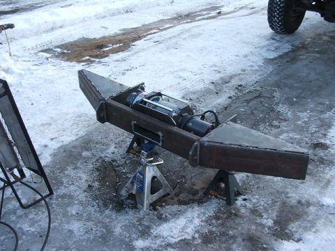 1990 Chevrolet Suburban - A custom steel bumper assembly, complete with a winch, is supported by jack stands on a snowy surface.