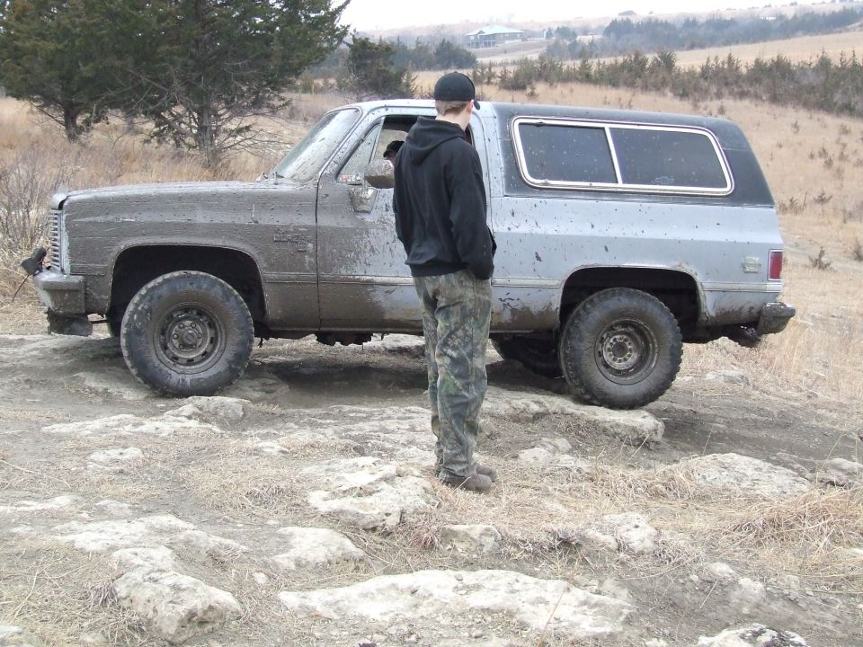 Mud-covered SUV, side view, light blue and silver