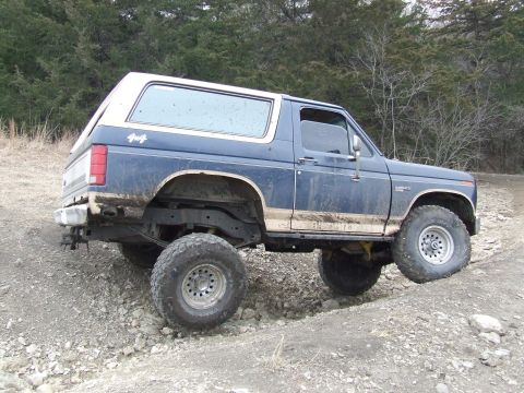 1986 Ford Bronco - This 1980 Ford Bronco navigates a challenging, rocky path, its off-road capabilities.
