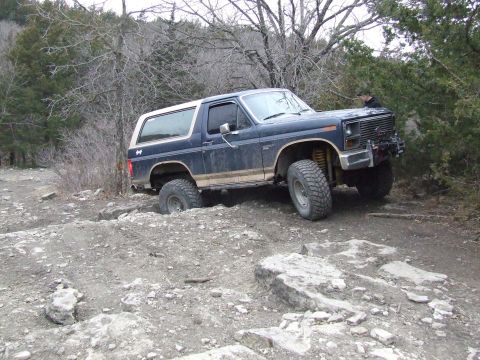1986 Ford Bronco - This 1986 Ford Bronco is shown off-roading over a challenging rocky landscape.