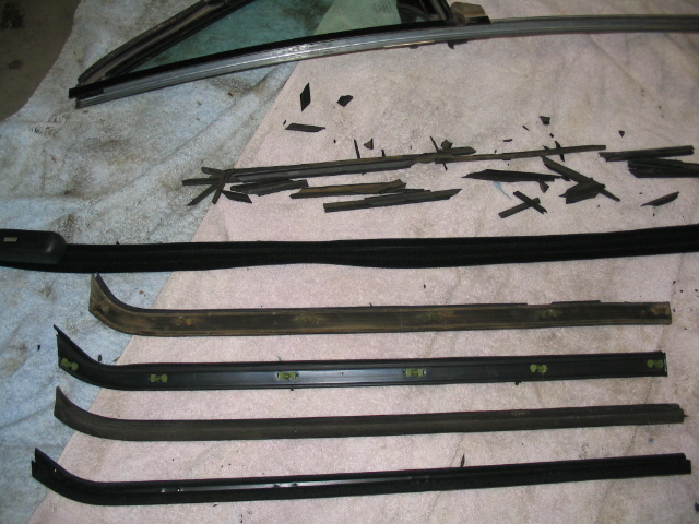 Window trim pieces and broken rubber seals laid out on a cloth