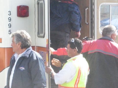 1990 Ford Bronco - Several people stand at the open back of an ambulance marked 3995, including a man in a high-visibility yellow safety vest.