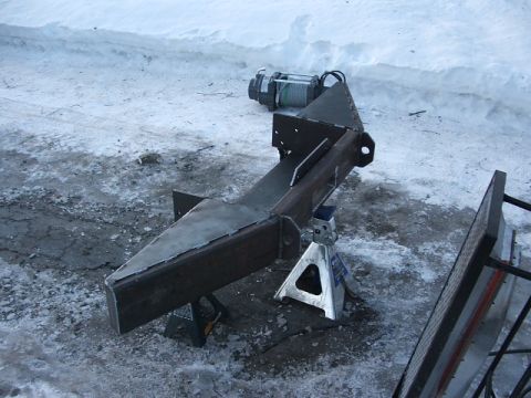 1990 Chevrolet Suburban - A custom-built bumper assembly, complete with a winch, is shown supported by jack stands on a snowy surface.