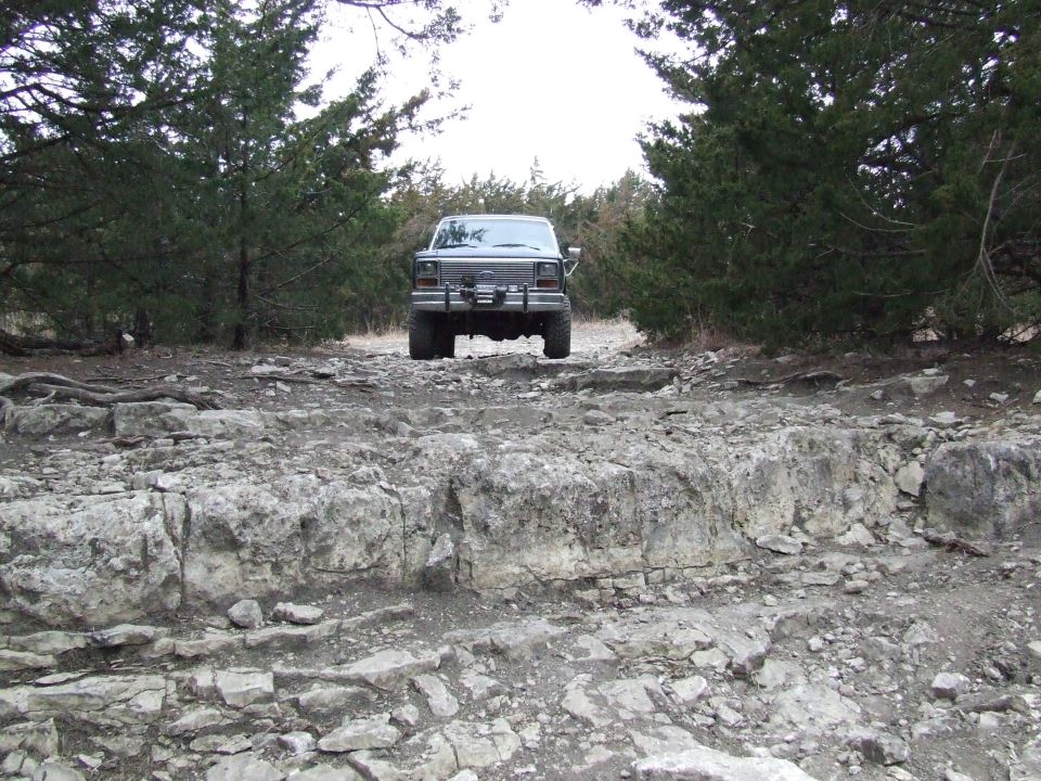 Rear view of a 1986 Ford Bronco on a rocky off-road trail