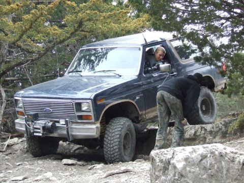 1986 Ford Bronco - Ford Bronco tackling rough terrain with assistance from a passenger.