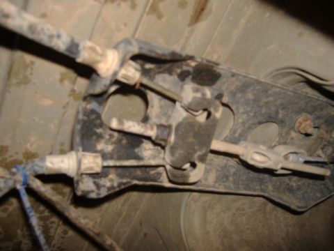 2004 Jeep Wrangler - Underbody view of a vehicle's brake cable mechanism, showing linkages and housing.