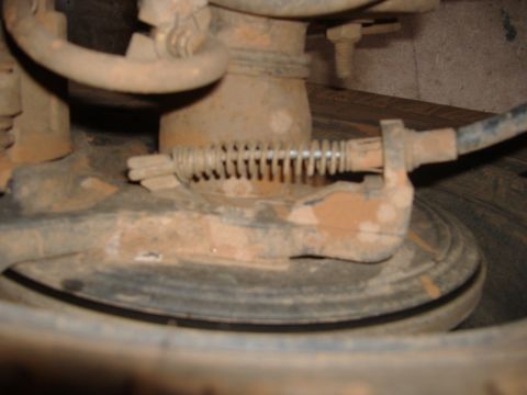 2004 Jeep Wrangler - Close-up of a rusty brake assembly on a 2004 Jeep Wrangler, showing mechanical parts and a coiled spring.