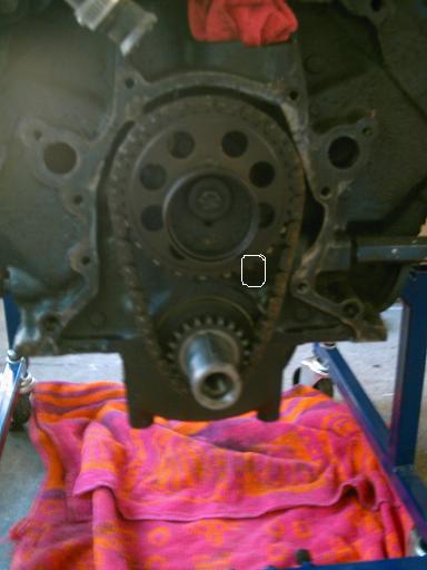 1986 Ford Bronco - The engine's timing chain and gears are visible, with a red cloth and blanket beneath.