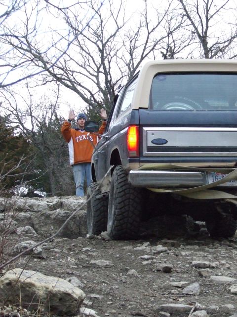 1986 Ford Bronco - A Ford Bronco is seen from the rear on a rocky trail with a person standing behind it.
