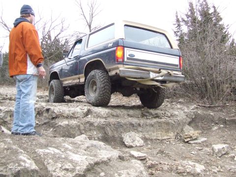1986 Ford Bronco - This 1986 Ford Bronco navigates a rocky trail, demonstrating its off-road capabilities.