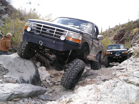1993 Ford Bronco - Two Ford Broncos navigate a rocky trail, their off-road capabilities.