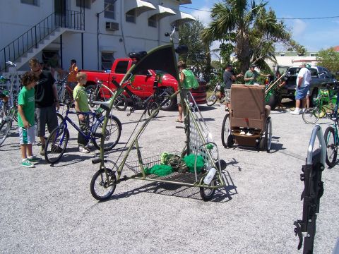 1994 Ford Probe - A group of people and various bicycles are gathered around a custom-built pedal-powered vehicle.