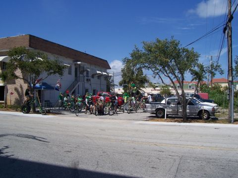 1994 Ford Probe - A group of cyclists and their bikes are assembled outside a building on a sunny day.