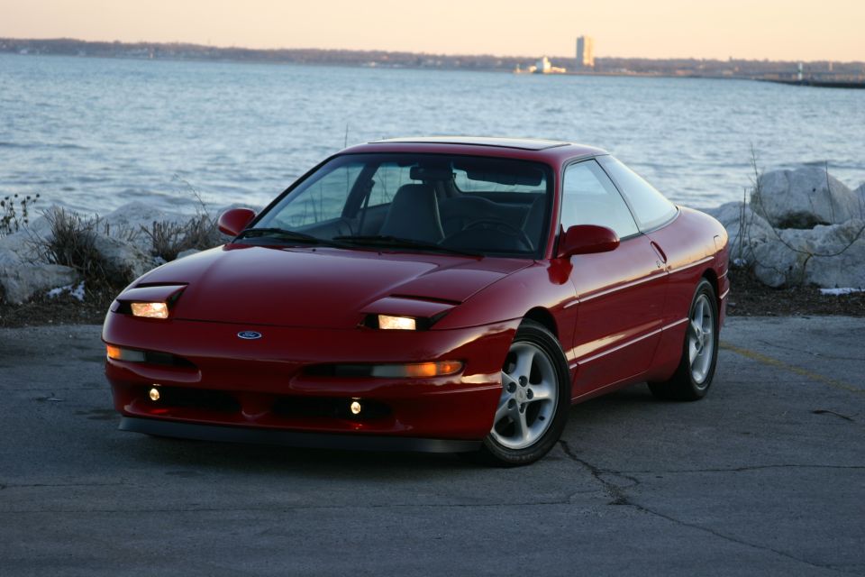 Red 1993 Ford Probe parked by the water, front three-quarter view