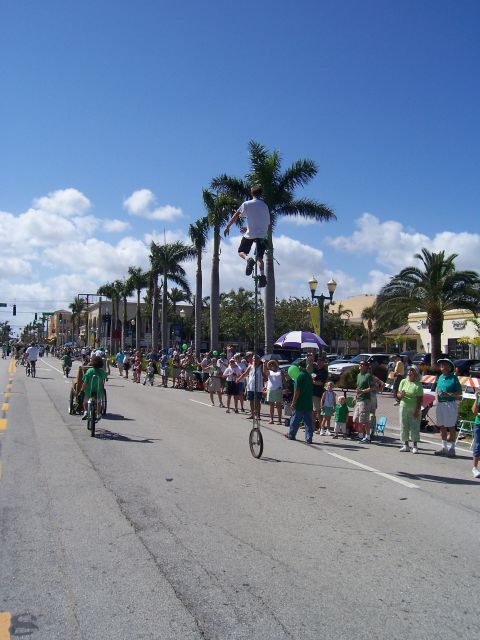 1994 Ford Probe - A parade is underway with spectators lining the street and a performer on a very tall unicycle.