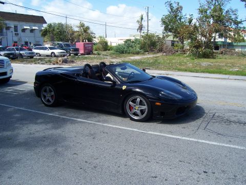 1994 Ford Probe - Black convertible sports car with distinctive wheels and red brake calipers is seen from the side.