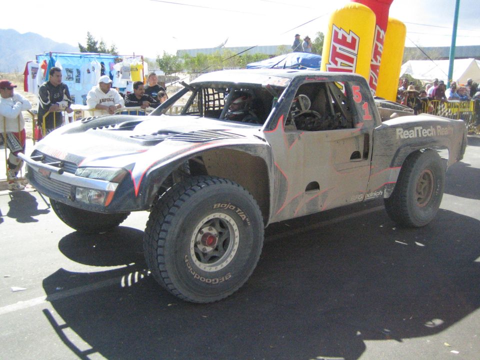 Silver and black RealTech off-road race truck on pavement