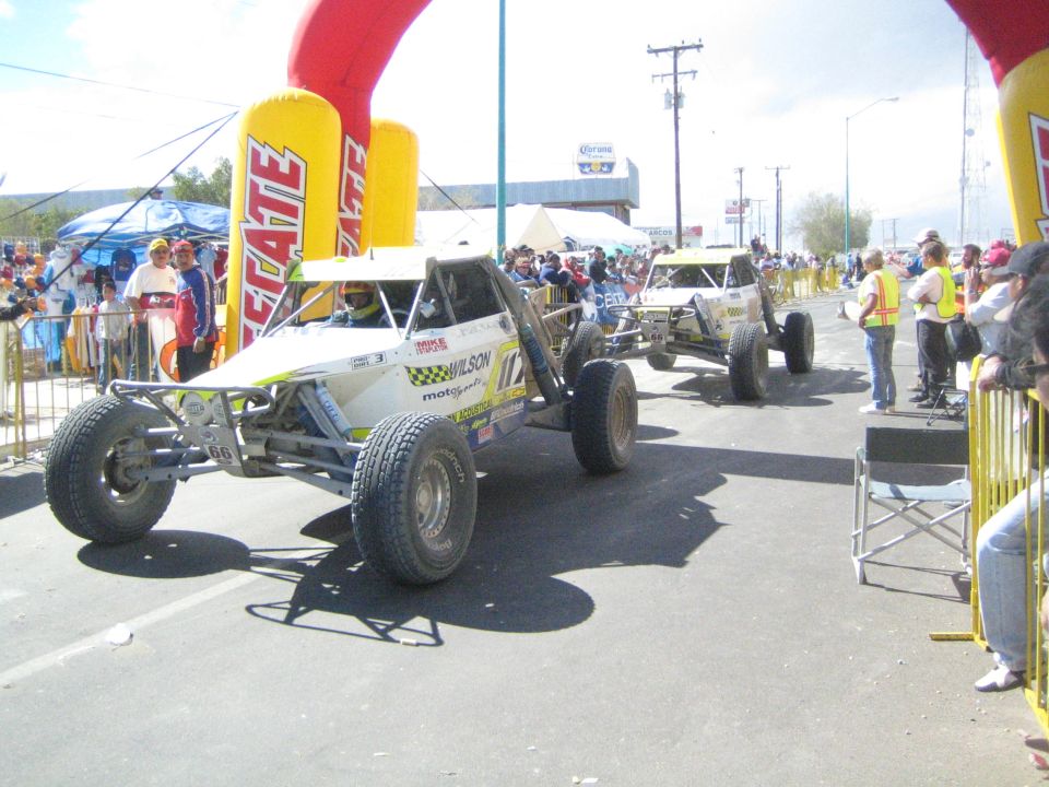 Two open tube-frame off-road race buggies on the course