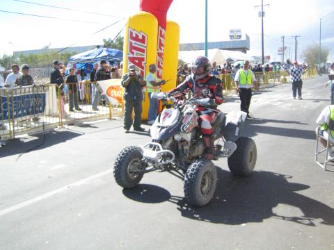 White and red ATV quad racer number 7 on the course