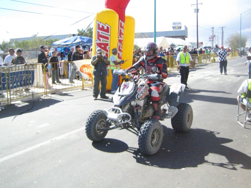 White and red ATV quad racer number 7 on the course