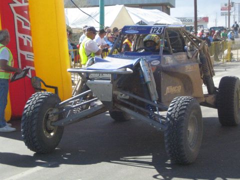 Silver and blue tube-frame race buggy number 124 on pavement