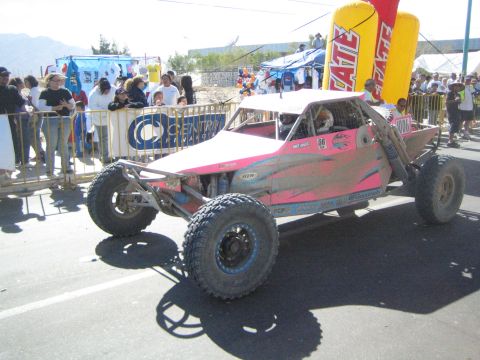 Pink and white tube-frame off-road race buggy on pavement
