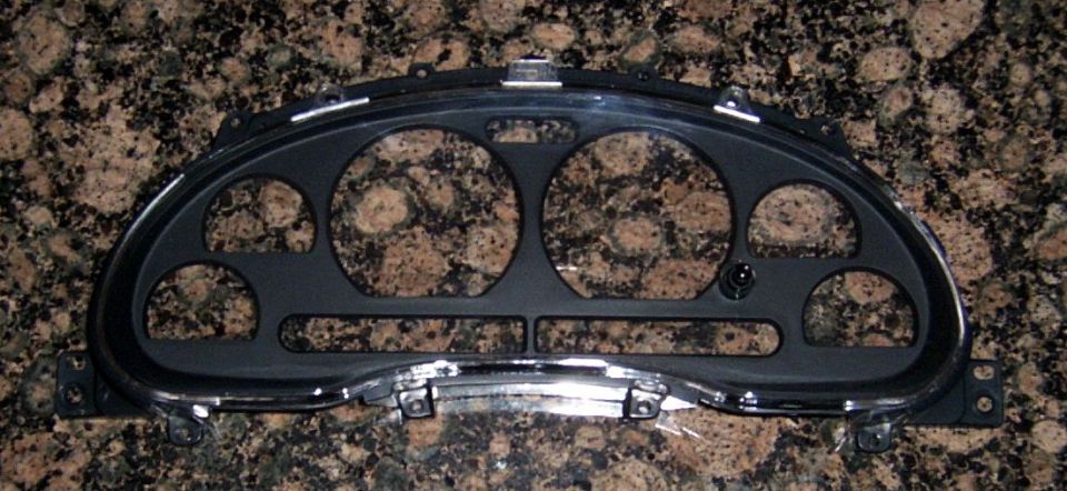 Black instrument cluster bezel with multiple circular and rectangular openings, chrome trim accents, and a "SUPER MOTORS" watermark