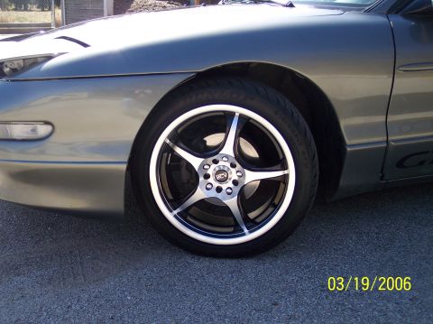 1995 Ford Probe - Close-up of a 1995 Ford Probe's front wheel and fender area.