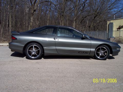 1995 Ford Probe - A gray 1995 Ford Probe GTS is shown from the side, aftermarket wheels and a spoiler.