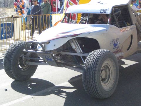 White single-seat off-road race buggy number 138 on pavement