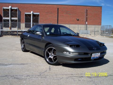 1995 Ford Probe - This 1995 Ford Probe is shown in a 3q-front view, aftermarket rims and a dark grey paint job.