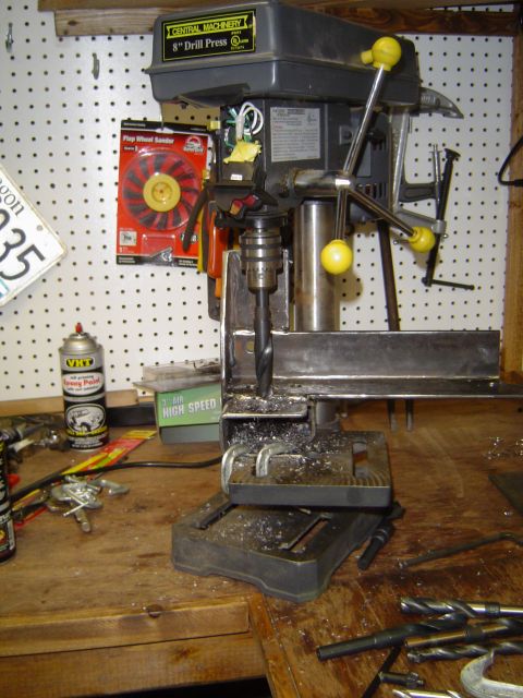 1989 Ford Bronco - Drill press in use, creating metal shavings on a cluttered workbench.