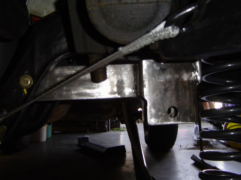 Fresh welded bare steel brackets on truck frame with coil spring and bump stop