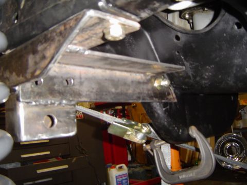 1989 Ford Bronco - Close-up view of custom bracketry and a C-clamp on a vehicle's undercarriage.
