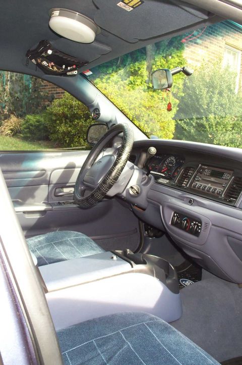 1998 Ford Crown Victoria - The interior of the vehicle shows the dashboard, steering wheel, and front seats.