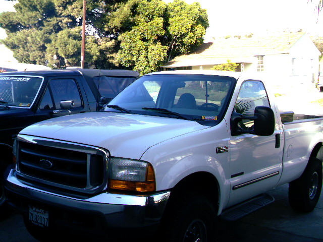 White Ford Super Duty regular cab pickup, front three-quarter view in a driveway