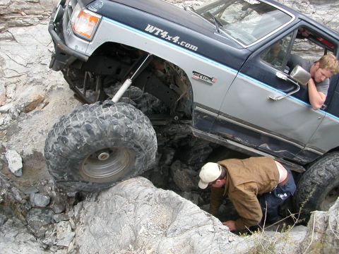 1984 Ford Bronco - This 1984 Ford Bronco navigates a challenging rocky terrain, with a person looking under the vehicle.