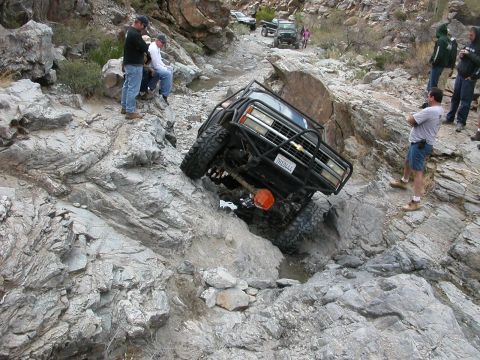1984 Ford Bronco - Several vehicles are seen on a rocky trail with people observing.