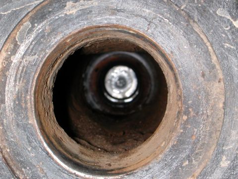 1984 Ford Bronco - Interior view of a corroded metal tube, showing significant rust and debris within.