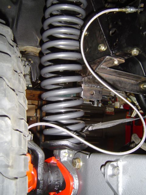 1989 Ford Bronco - Suspension coil spring and tire detail, likely part of an axle installation.