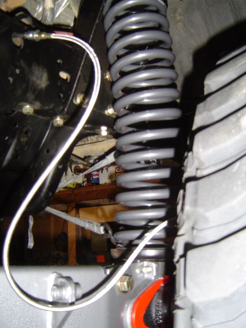 1989 Ford Bronco - A close-up view of a vehicle's suspension system, focusing on the coil spring and tire.