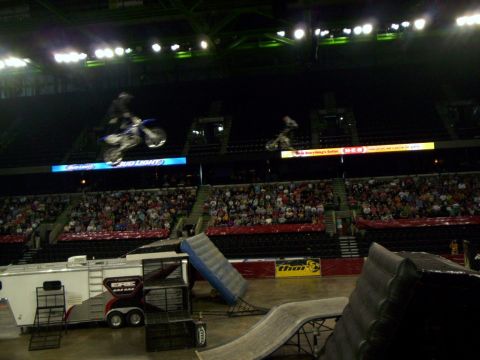 1986 Ford Bronco - Motocross riders perform stunts during an event in a stadium with a large audience.