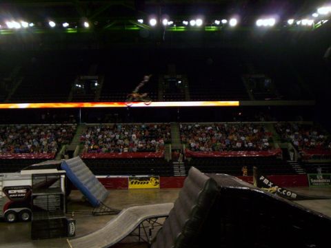 1986 Ford Bronco - Freestyle motocross event with rider performing a jump in an arena.
