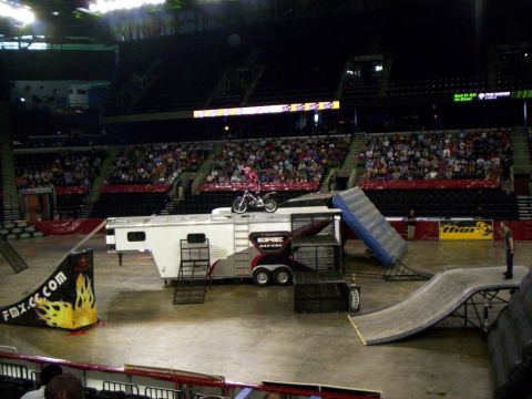 1986 Ford Bronco - A motocross rider performs a stunt on a trailer during an event with spectators.