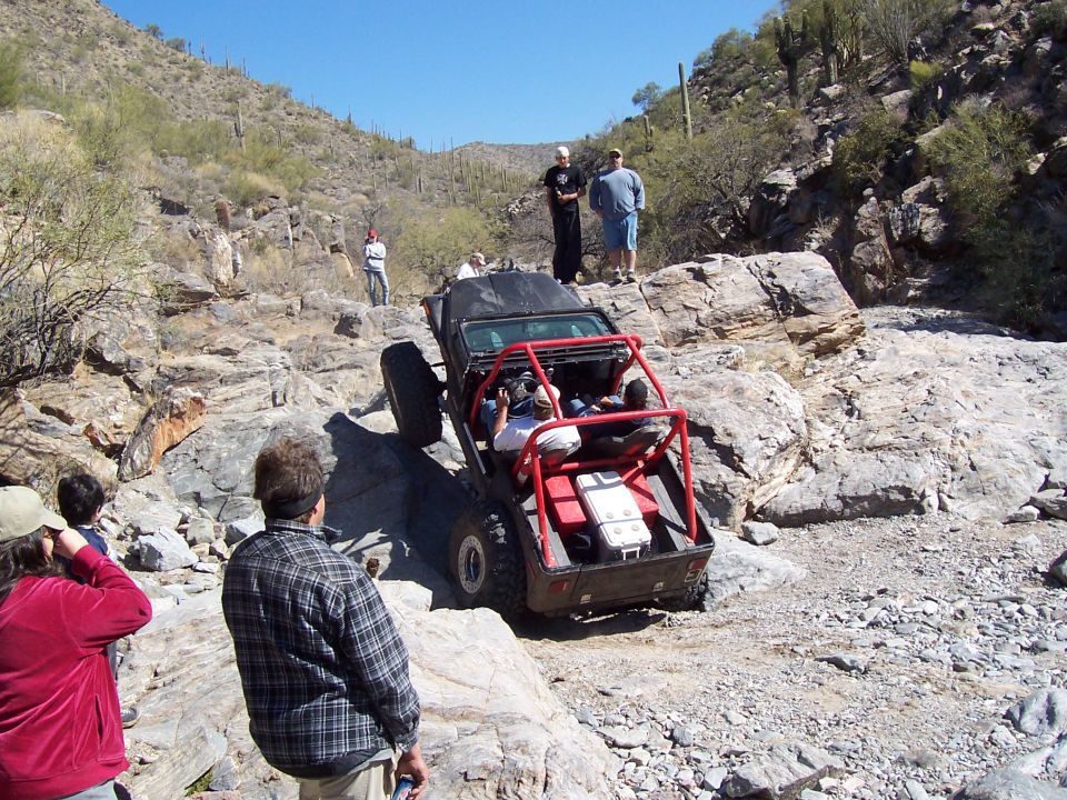 Off-road vehicle with roll cage climbing rocky terrain