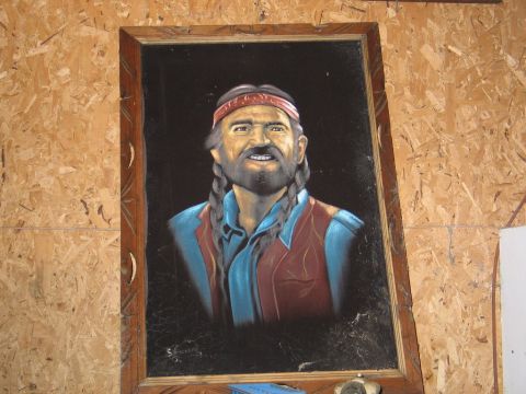 1989 Ford F-150 - This is a portrait of a man with braids and a red bandana, framed and hanging on a wood-paneled wall.