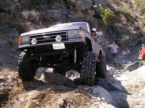 1993 Ford Bronco - This modified Ford Bronco is shown off-roading on a steep, rocky trail.