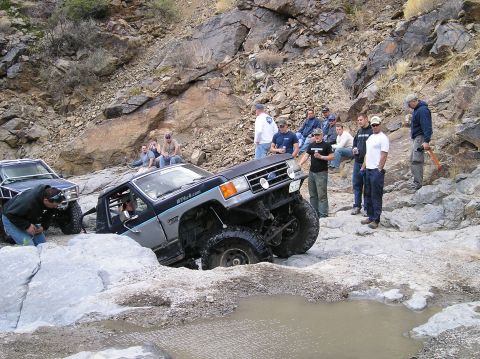 1993 Ford Bronco - A group watches as a modified 1987 Ford Bronco navigates difficult rocky terrain.
