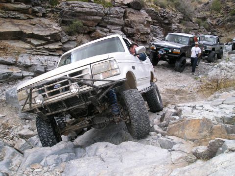 1993 Ford Bronco - Multiple off-road vehicles traverse a , rocky terrain.
